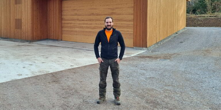Marc Bodmer vor dem neuen Werkhof im Zolliker Wald. Für die Fassaden wurde Holz aus dem eigenen Revier verwendet. (Bild: jjm)